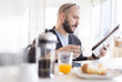 © JGI/Tom Grill/Blend Images - Hispanic man reading newspaper at breakfast