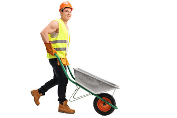 Wall Mural - Worker pushing an empty wheelbarrow