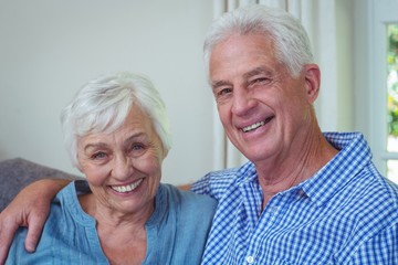 Wall Mural - Portrait of smiling retired couple with arm around 