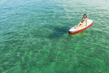 Woman Relaxing Over A Paddle Surfboard