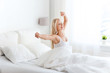 © Syda Productions - young woman stretching in bed after waking up