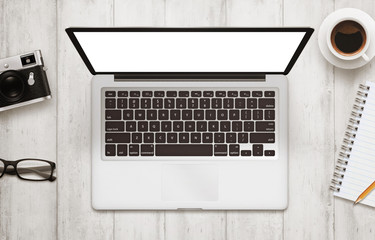 Leinwandbilder - Laptop with isolated white screen for mockup. Work desk with camera, glasses, coffee, notepad and pencil beside on wooden table. Top view.