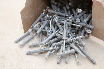 carton box ful of screws with wall plugs