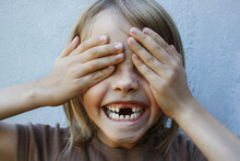 Boy With Gap Toothed Smile With Hands Covering Eyes