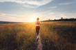 Young sporty girl running on a rural road at sunset in summer field. Lifestyle sports background  