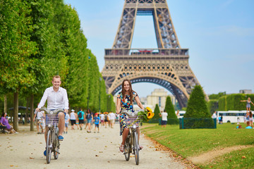 Wall Mural - couple riding bicycles near the Eiffel tower in Paris