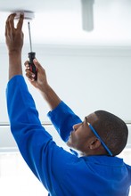 Handyman Fixing The Smoke Detector With Screwdriver