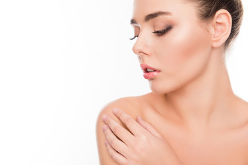 Wall Mural - Close up portrait of minded woman touching her shoulder on white