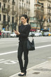 © Westend61 - Spain, Catalunya, Barcelona, young black dressed businesswoman telephoning in front of a street