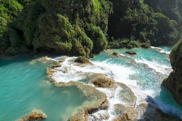 Wall Mural - Downstream of a river with turquoise water between rocky shores