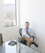 © Sam Diephuis/Blend Images - Caucasian businessman using cell phone at desk in office