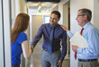 © Sam Diephuis/Blend Images - Business people shaking hands in office hallway