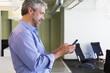 © Don Mason/Blend Images - Caucasian businessman using cell phone in office