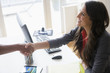 © JGI/Jamie Grill/Blend Images - Business people shaking hands at desk in office