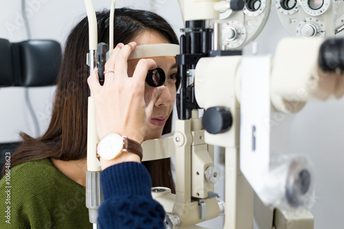 Fotomural Woman having her eyes examined by eye doctor