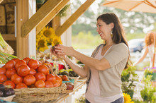 Hispanic Woman Browsing Fruit At Farmers Market