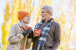 © Mike Kemp/Blend Images - Older Caucasian couple drinking coffee near autumn trees