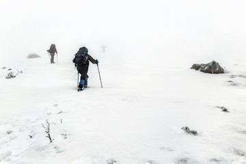 mountain hiking group in snow storm