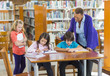 © Marc Romanelli/Blend Images - Teacher helping students in library