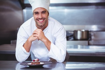 Wall Mural - Chef leaning on the counter with a dessert