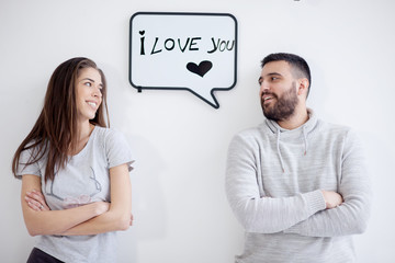 Young couple showing love message written on white board. I love you message. 