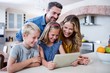© WavebreakMediaMicro - Parents and kids using digital tablet in kitchen