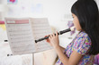 © JGI/Jamie Grill/Blend Images - Vietnamese girl playing recorder from sheet music