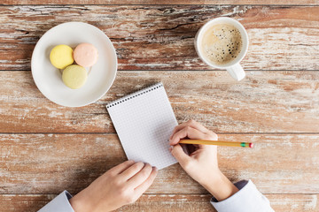 Canvas Print - close up of hands, notebook, coffee and cookies