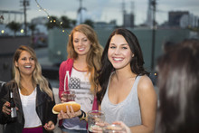 Female Friends Enjoying Food At Rooftop Barbecue