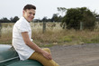 © Connect Images - Portrait of young man sitting on bonnet of vintage morris minor