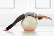 © Connect Images - Young woman stretching on exercise ball