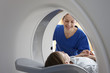© Connect Images - Radiographer smiling at girl inside CT scanner
