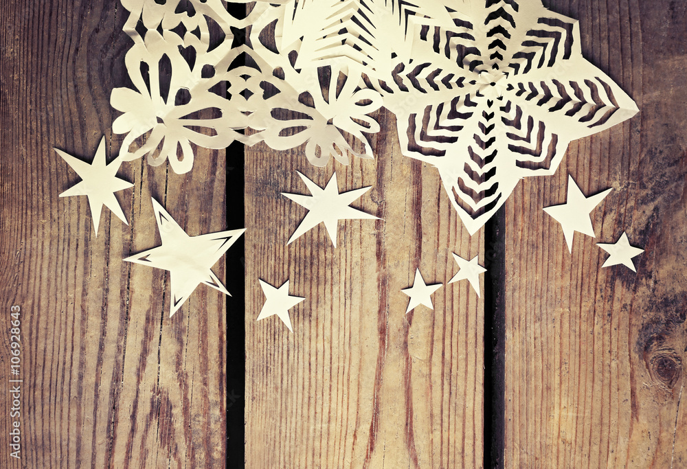 Winter background with hand-made paper snowflakes on wooden background