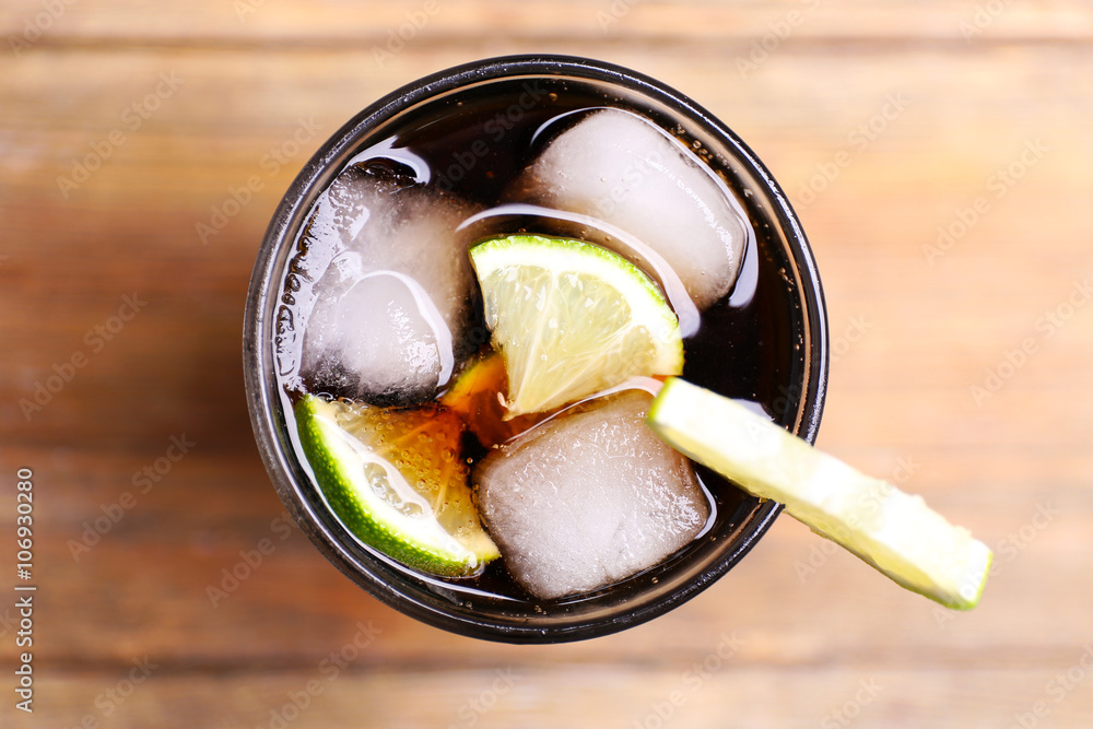 Cocktail with lime slices and ice blocks on wooden table, top view - obrazy, fototapety, plakaty 