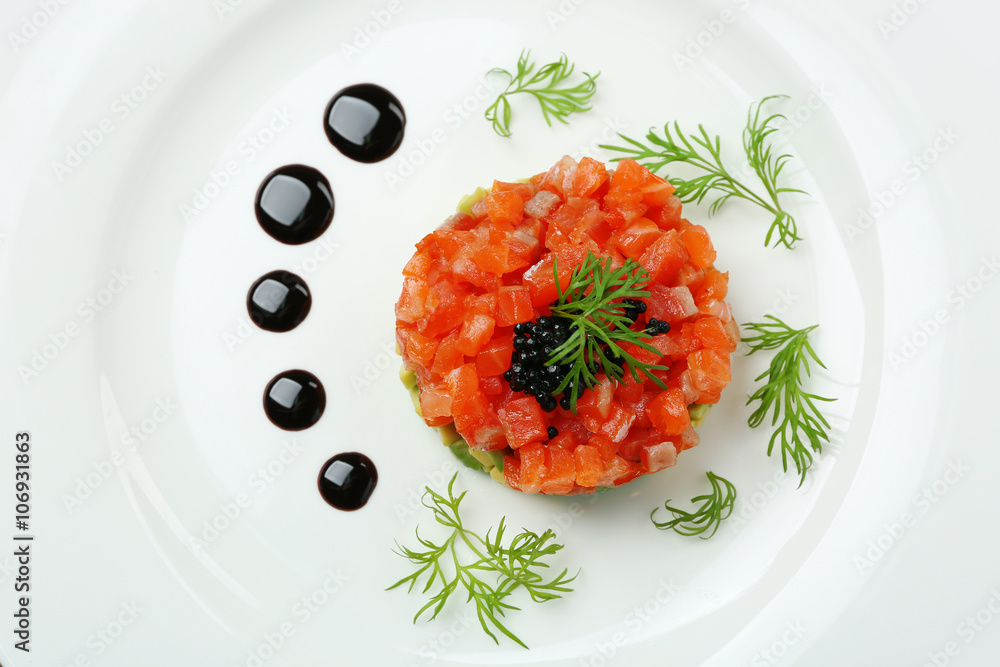 Delicious salmon tartare with black caviar on white plate