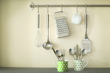 Wall Mural - Set of metal kitchen utensils with cup hanging on the wall and cutlery