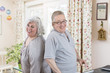 © Connect Images - Portrait of mature couple back to back in sitting room