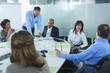 © Connect Images - Businessmen and women chatting around boardroom table