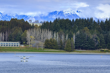 water plane floating over fresh water lake against beautiful mou