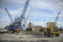 Crane And Digger Loading Recycled Glass Onto Ships