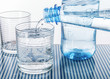 Mineralwasser aus blauer Flasche in ein Glas eingeschenkt