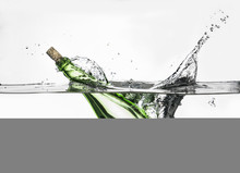 Surface Level View Of Green Bottle Splashing Into Clear Water