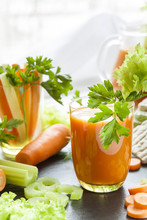 Fresh Carrot Juice With Carrots, Celery And Parsley On Black Background