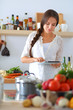 © lenets_tan - Young woman using a tablet computer to cook in her kitchen