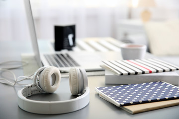 Wall Mural - Headphones and laptop on white table against defocused background