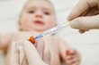 Doctor holds syringe to vaccinate  baby 