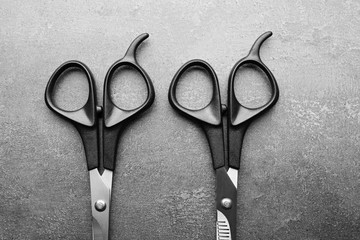 Wall Mural - Professional scissors with black handles on a dark grey surface, top view