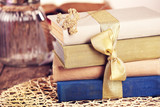 Fototapeta Lawenda - Stack of old books tied with yellow ribbon on a table, close up