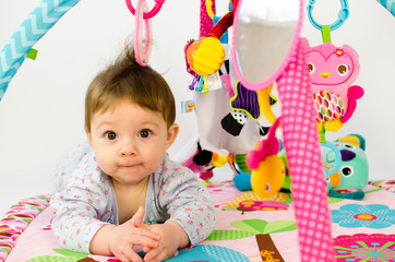 baby girl playing in an activity gym