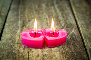 Heart-shaped candle on the old wooden floor.